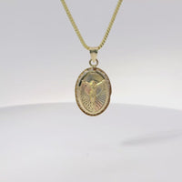 14KT Gold Charm Medium Oval Tri Tone Graphic Line Background with Crucifix Center Coin with White CZ Stones Frame Edge and Plain Bell