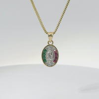 14KT Gold Charm Small Tri Tone Oval Virgin Mary with Red, Green, and White Round CZ Stones Border with Plain Bell